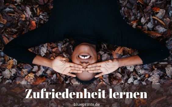 Glückliche Frau liegt im Laub.
