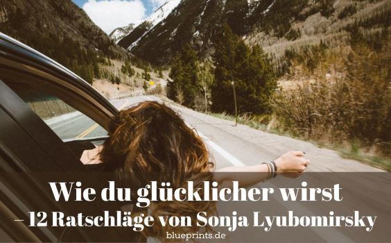 Frau hält den Kopf aus dem Autofenster und freut sich.